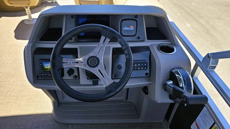 Slide: The Image of 2025 Sun Tracker Fishin' Barge 20 DLX steering console with modern controls and cup holder. - 9