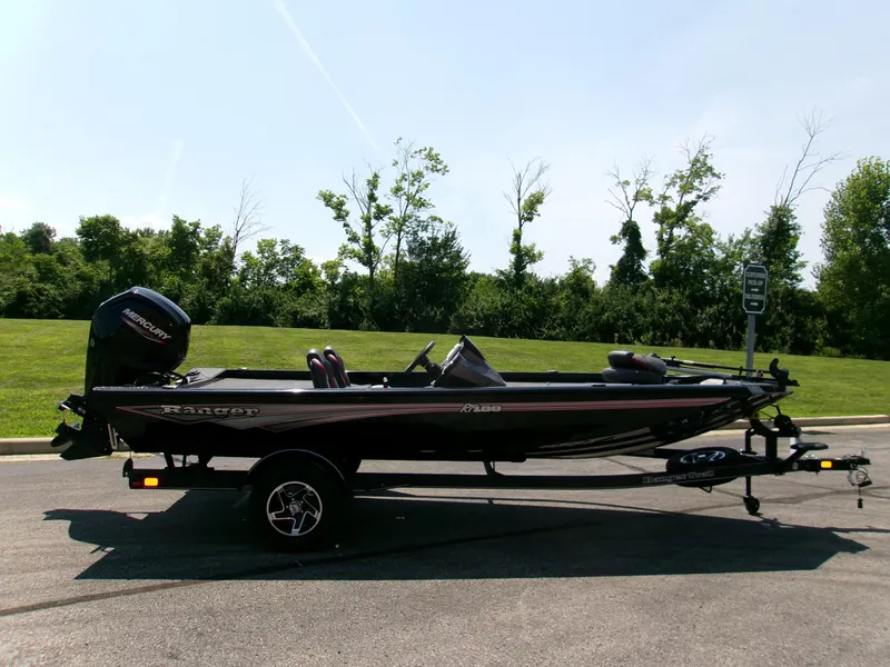 The Image of 2025 Ranger RT188 boat on trailer, parked outdoors with green trees in background. - 0