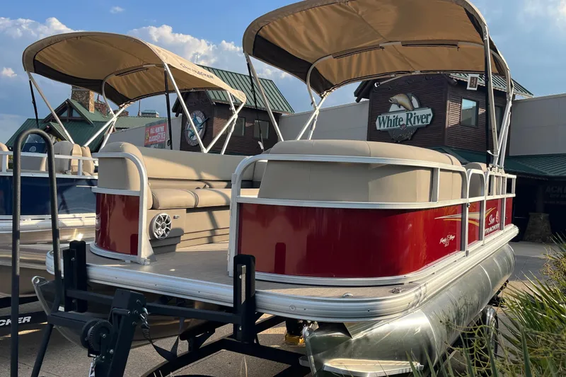 The Image of 2025 Sun Tracker Party Barge 18 DLX pontoon boat with canopy, displayed outdoors. - 0