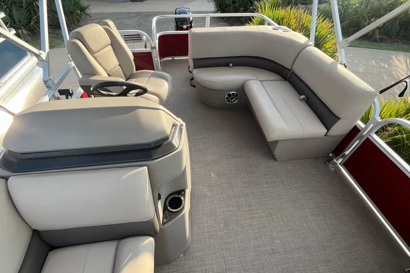 Slide: The Image of 2025 Sun Tracker Party Barge 18 DLX interior with plush seating and steering console. - 6