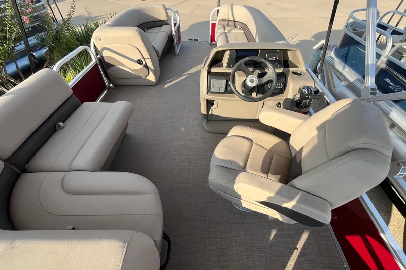 Slide: The Image of 2025 Sun Tracker Party Barge 18 DLX interior with beige seating and steering console. - 8