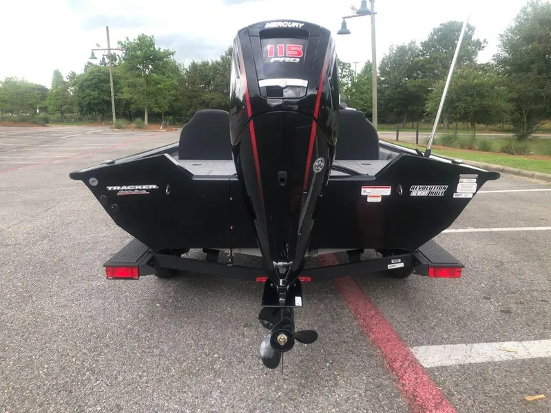Slide: The Image of 2025 Tracker Pro Team 190 boat with Mercury 115 Pro XS engine in a parking lot. - 2