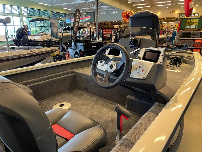 Slide: The Image of 2025 Tracker Pro Team 175 Crappie Edition boat interior with steering wheel and seating. - 2
