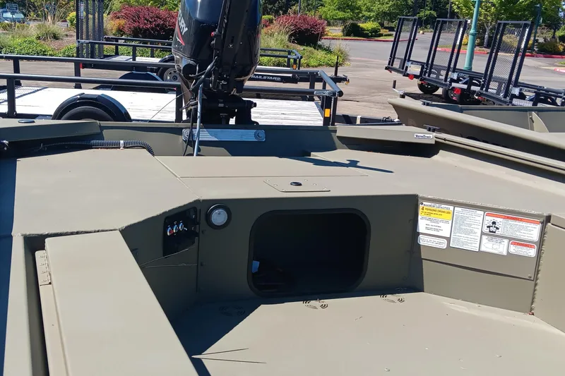 Slide: The Image of 2025 Tracker Grizzly 1654 T Sportsman boat interior with motor and control panel. - 2