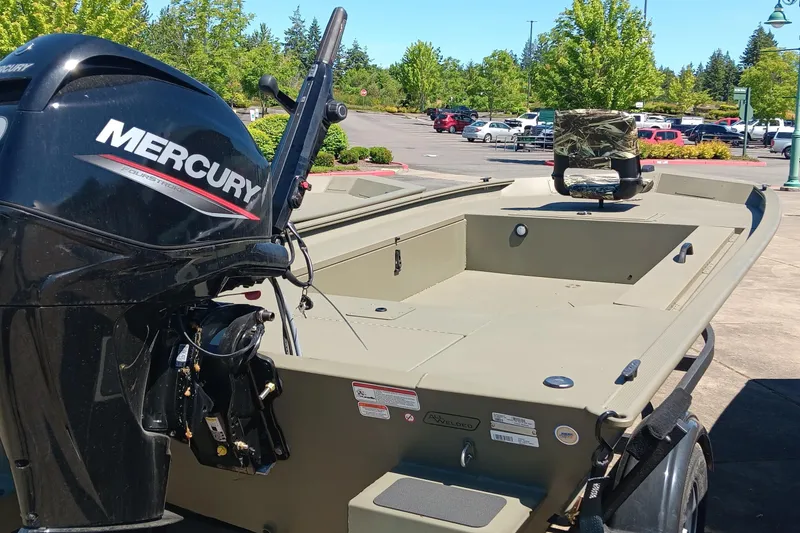 Slide: The Image of 2025 Tracker Grizzly 1654 T Sportsman boat with Mercury engine in a parking lot. - 4