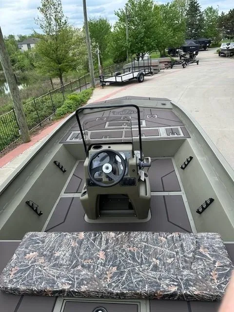 Slide: The Image of 2025 Tracker Grizzly 2072 CC boat with center console, camo seat, and spacious deck. - 2