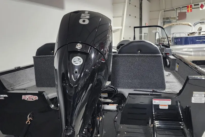 Slide: The Image of 2025 Tracker Pro Guide V-175 Combo boat with powerful 150 HP engine in showroom. - 14