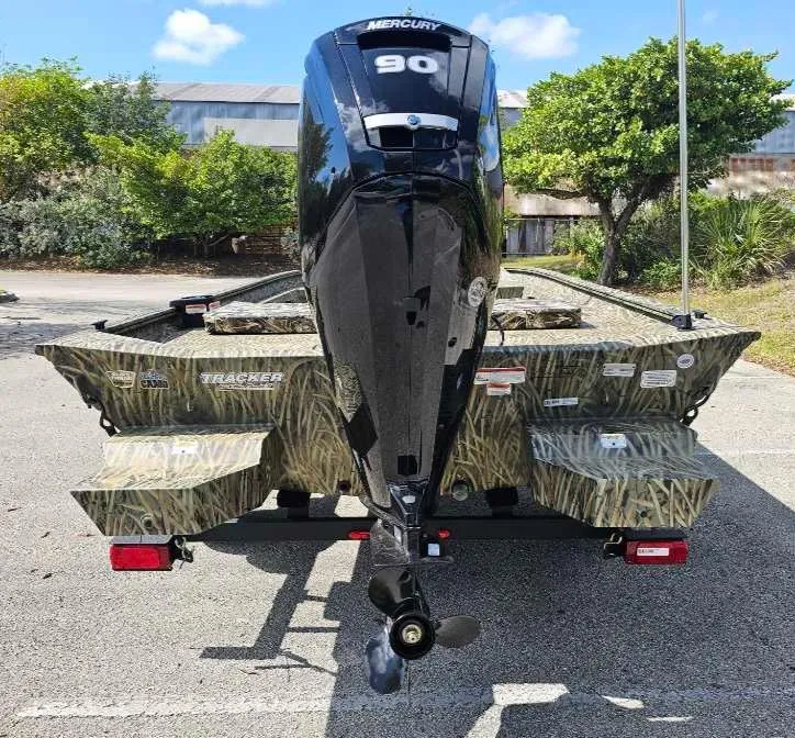 Slide: The Image of 2025 Tracker Grizzly 1860 CC boat with Mercury 90 engine, parked outdoors. - 10