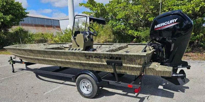 Slide: The Image of 2025 Tracker Grizzly 1860 CC boat with Mercury engine on trailer, parked outdoors. - 7