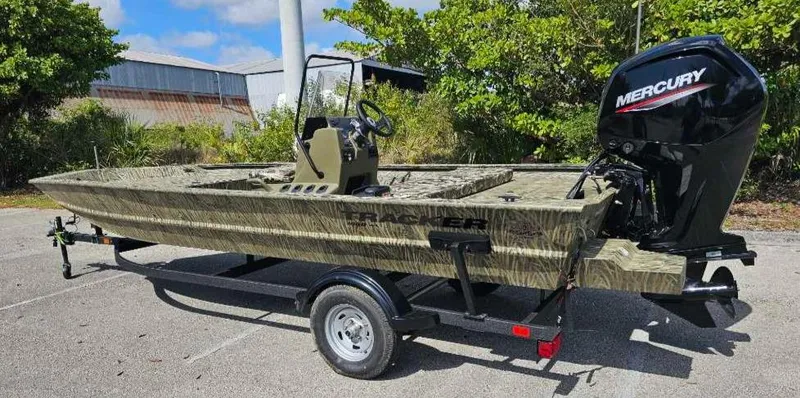 Slide: The Image of 2025 Tracker Grizzly 1860 CC boat with Mercury engine on trailer, parked outdoors. - 8