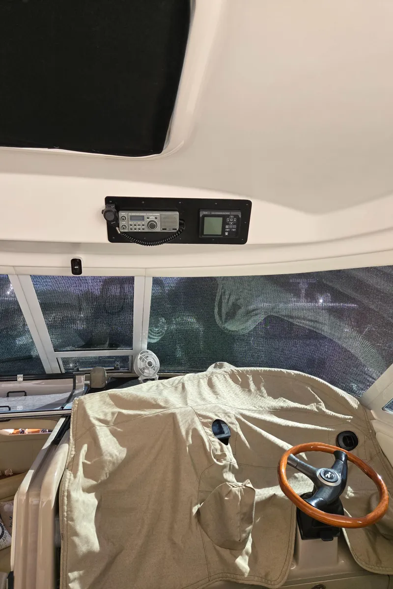 Slide: The Image of 2003 Sea Ray 390 Motor Yacht helm with covered controls and wooden steering wheel. - 30