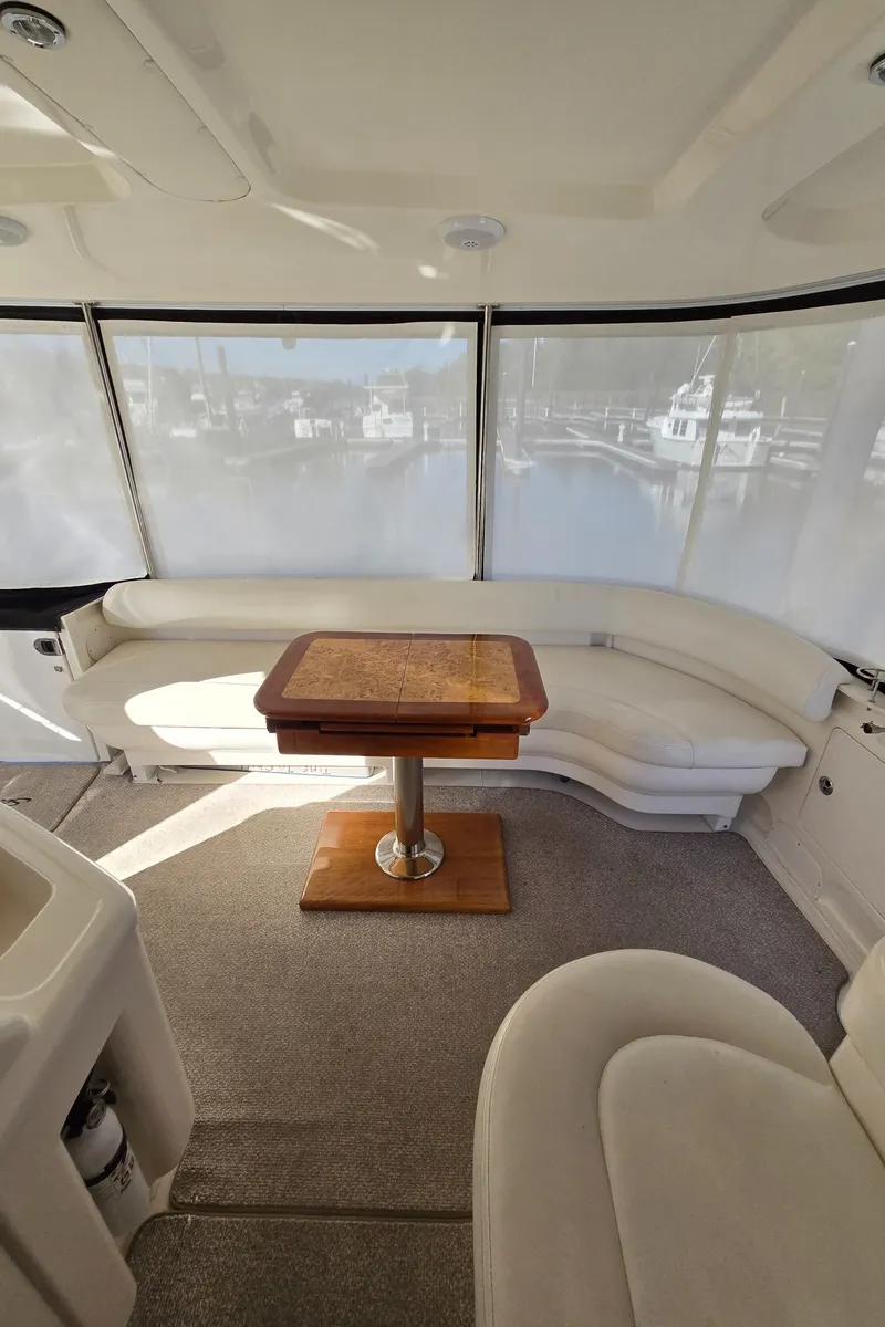 Slide: The Image of 2003 Sea Ray 390 Motor Yacht interior with curved seating and wooden table. - 35