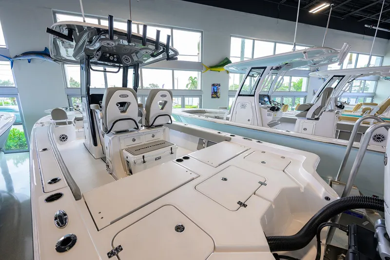 Slide: The Image of 2025 Sportsman Masters 267 Bay Boat interior in showroom, showcasing seating and control panel. - 11