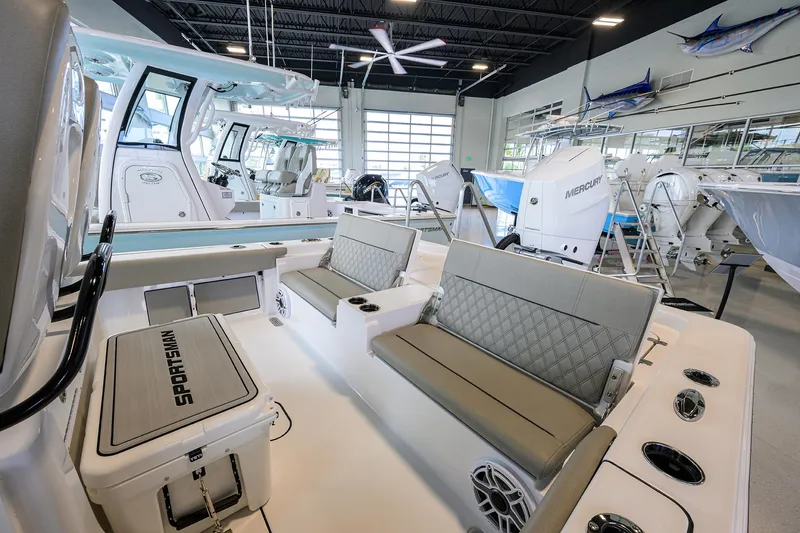 Slide: The Image of 2025 Sportsman Masters 267 Bay Boat interior with seating and modern design in showroom. - 15