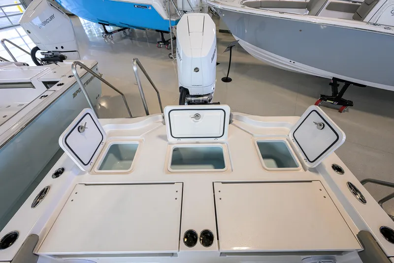 Slide: The Image of 2025 Sportsman Masters 267 Bay Boat with open storage compartments and outboard motor. - 16
