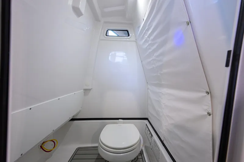 Slide: The Image of 2025 Sportsman Masters 267 Bay Boat interior bathroom with toilet and window. - 19