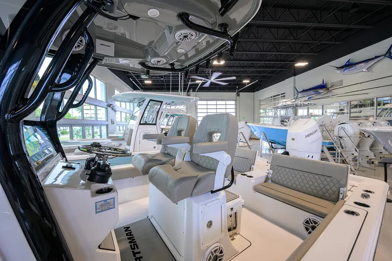 Slide: The Image of 2025 Sportsman Masters 267 Bay Boat interior with modern seating and controls in showroom. - 26
