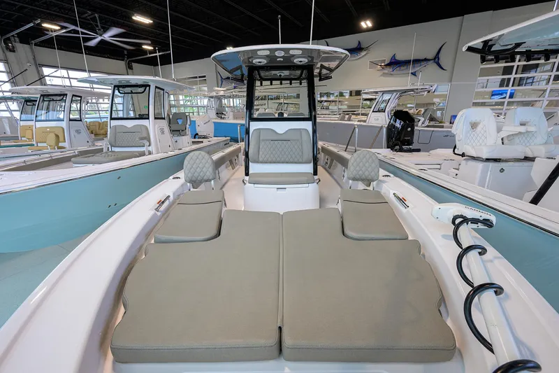 Slide: The Image of 2025 Sportsman Masters 267 Bay Boat interior with cushioned seating in showroom. - 5