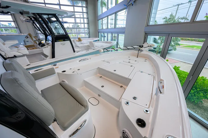 Slide: The Image of 2025 Sportsman Masters 267 Bay Boat interior, showcasing seating and deck features in a showroom. - 7