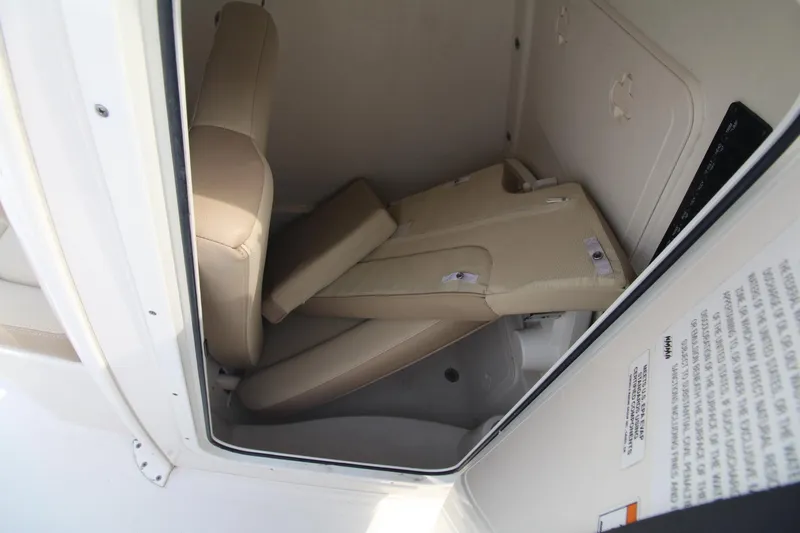 Slide: The Image of 2017 Sailfish 236 CC boat interior storage compartment with folded beige seats. - 13