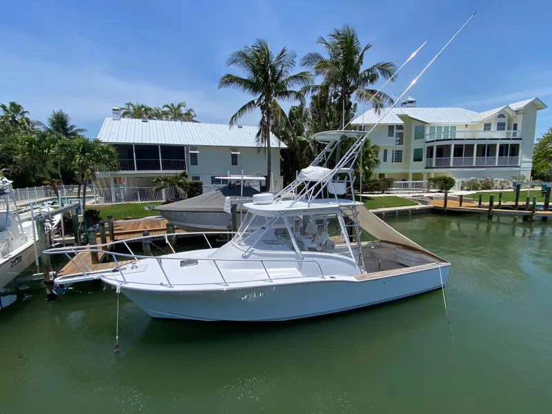 The Image of 1995 L&H 33 boat docked near waterfront homes with palm trees. - 0