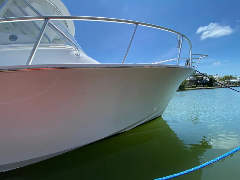 Slide: The Image of L&H 33 boat from 1995 docked on calm water under clear blue sky. - 11