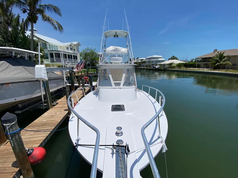Slide: The Image of A 1995 L&H 33 boat docked in a serene canal setting. - 12