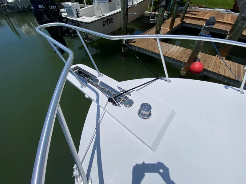 Slide: The Image of Bow of 1995 L&H 33 boat with railing and anchor, docked near wooden pier. - 14