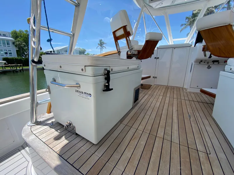 Slide: The Image of Deck of 1995 L&H 33 boat with cooler and seating, under clear blue sky. - 23