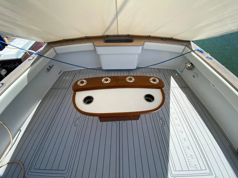 Slide: The Image of 1995 L&H 33 boat deck with wooden table and rod holders, under a canopy. - 36