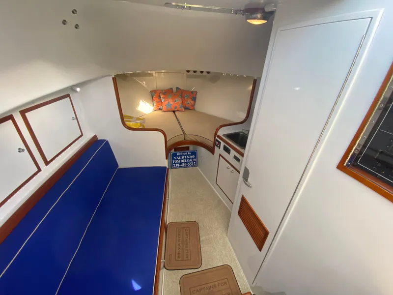 Slide: The Image of Interior of a 1995 L&H 33 boat with blue seating and cozy cabin space. - 46