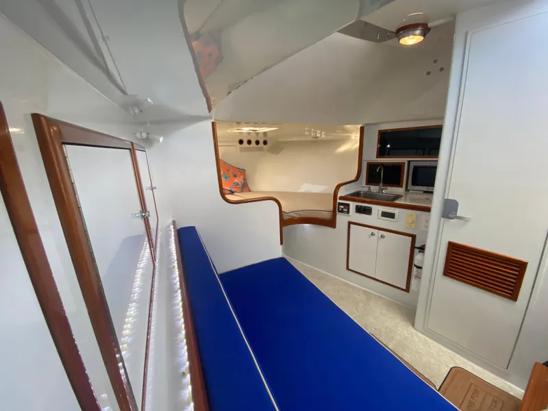 Slide: The Image of Interior of 1995 L&H 33 boat with blue seating and compact kitchen area. - 49