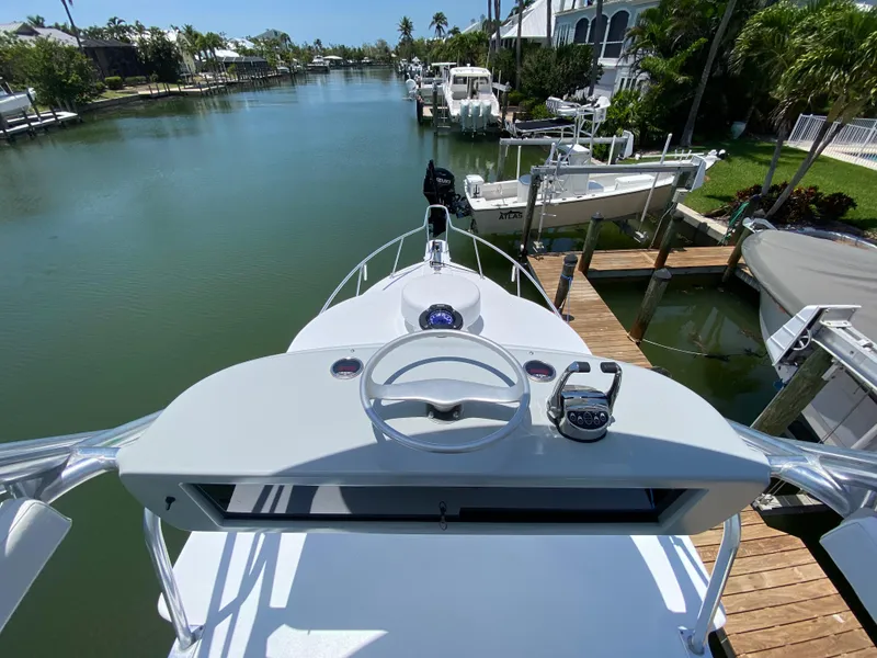 Slide: The Image of 1995 L&H 33 boat helm overlooking serene canal and docked boats. - 59