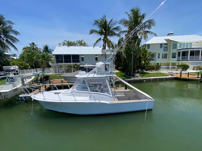 Slide: The Image of A 1995 L&H 33 boat docked in a tropical marina setting. - 7
