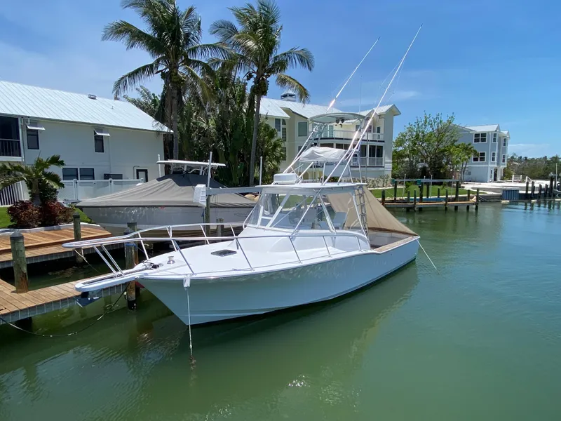 Slide: The Image of A 1995 L&H 33 boat docked in a sunny marina with palm trees. - 8