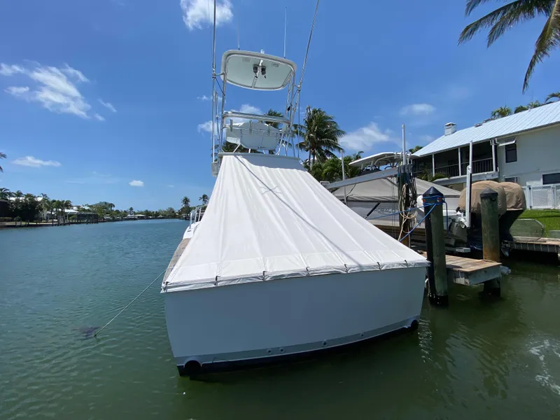 Slide: The Image of L&H 33 boat docked by waterfront, covered, under clear blue sky. - 9