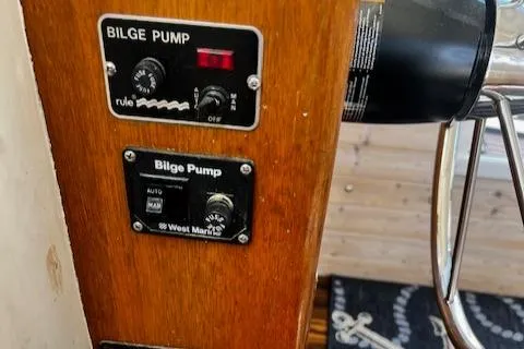 Slide: The Image of 1978 Bruno & Stillman Custom Cruiser bilge pump controls on wooden panel. - 12