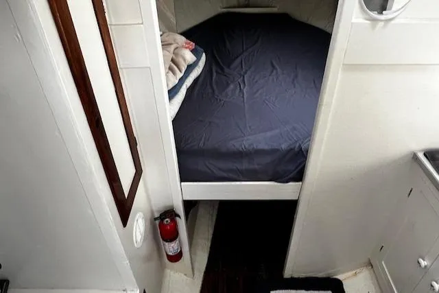 Slide: The Image of 1978 Bruno & Stillman Custom Cruiser cabin interior with bed, fire extinguisher, and mirror. - 17