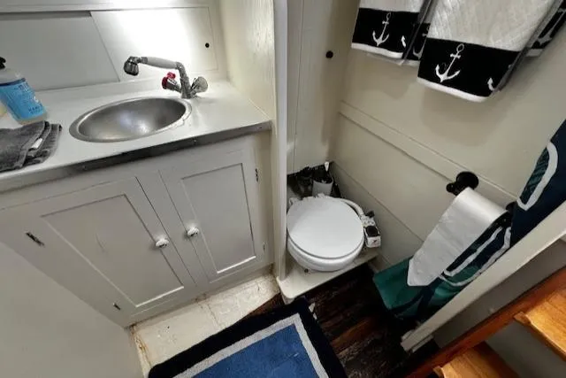 Slide: The Image of 1978 Bruno & Stillman boat bathroom with sink, toilet, and nautical-themed decor. - 19
