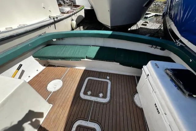 Slide: The Image of 1978 Bruno & Stillman Custom Cruiser/Sportfisherman boat interior with green seating and wooden deck. - 27