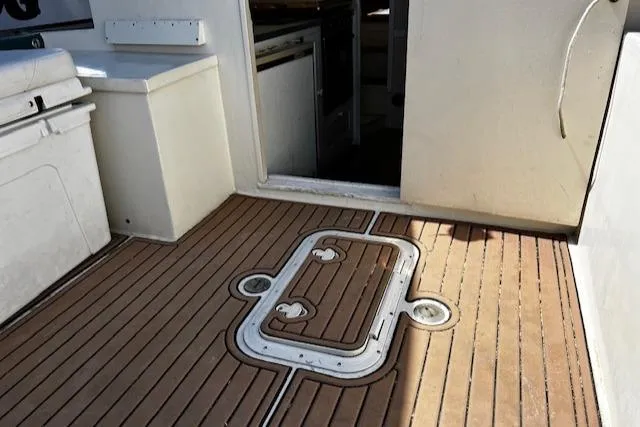 Slide: The Image of 1978 Bruno & Stillman Custom Cruiser/Sportfisherman boat deck with wooden flooring and hatch. - 28