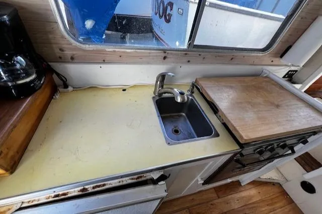 Slide: The Image of 1978 Bruno & Stillman boat kitchen with sink, cutting board, and coffee maker. - 4