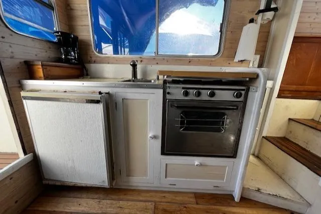 Slide: The Image of 1978 Bruno & Stillman boat kitchen with stove, sink, and wooden cabinetry. - 6