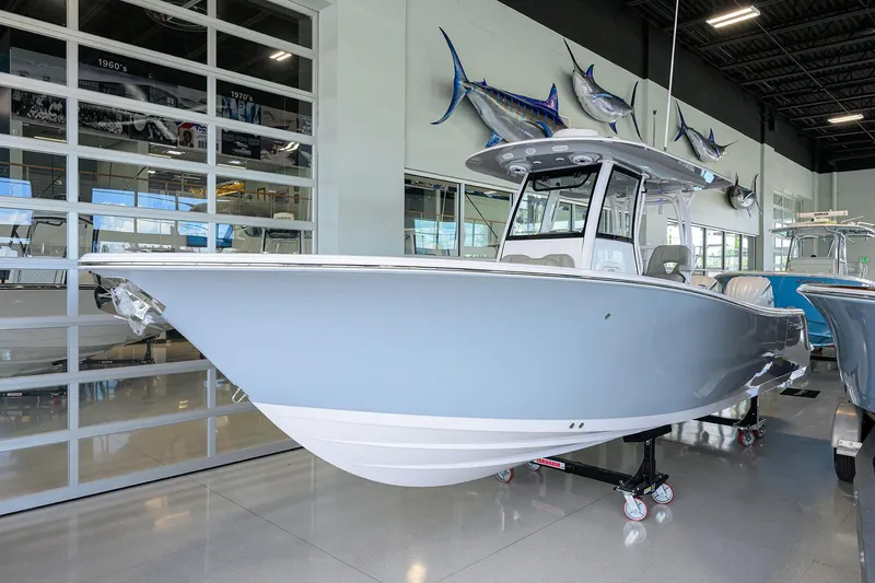 Slide: The Image of 2025 Sportsman Open 282 Center Console boat displayed in showroom, sleek design, modern features. - 2