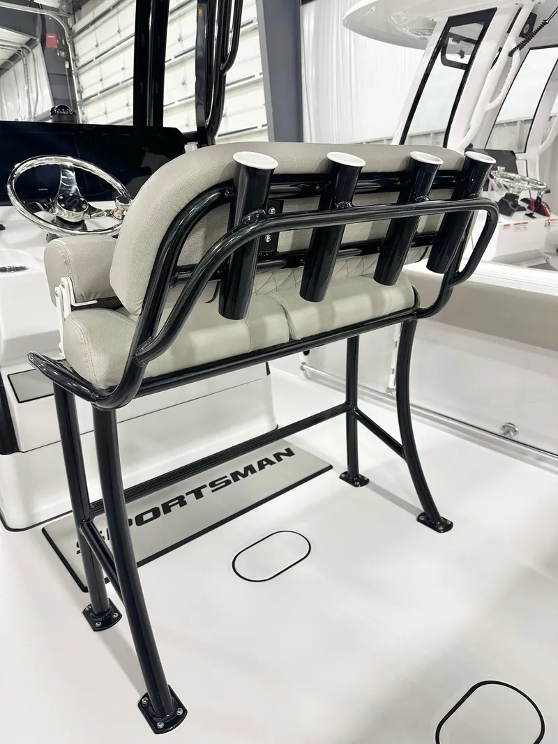 Slide: The Image of 2025 Sportsman Heritage 231 Center Console boat interior with rod holders and cushioned seating. - 4
