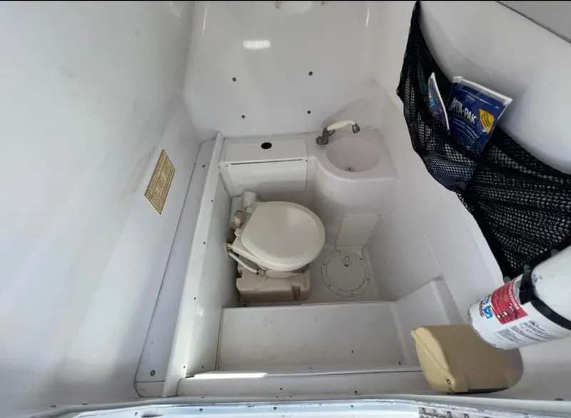 Slide: The Image of 1999 Donzi 35 ZF boat interior with toilet, sink, and storage net. - 13