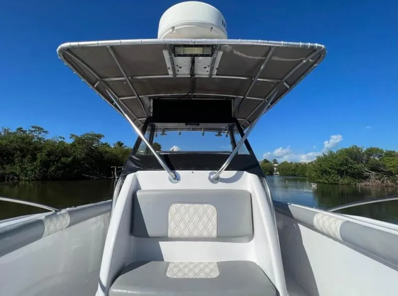 Slide: The Image of 1999 Donzi 35 ZF boat with canopy, cruising on a calm river under clear blue skies. - 8