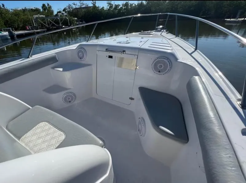 Slide: The Image of 1999 Donzi 35 ZF boat interior with seating and speakers, docked by a calm river. - 9