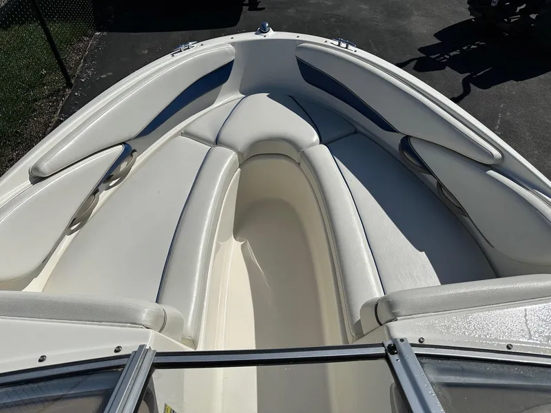 Slide: The Image of 2004 Bayliner 205 boat interior with white seating and open bow design. - 1