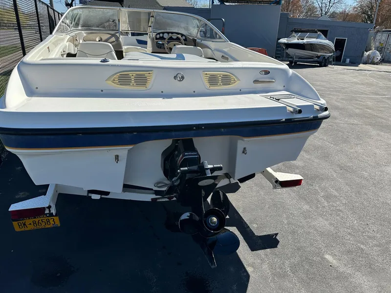 Slide: The Image of 2004 Bayliner 205 boat, rear view, parked on a trailer in a lot. - 2